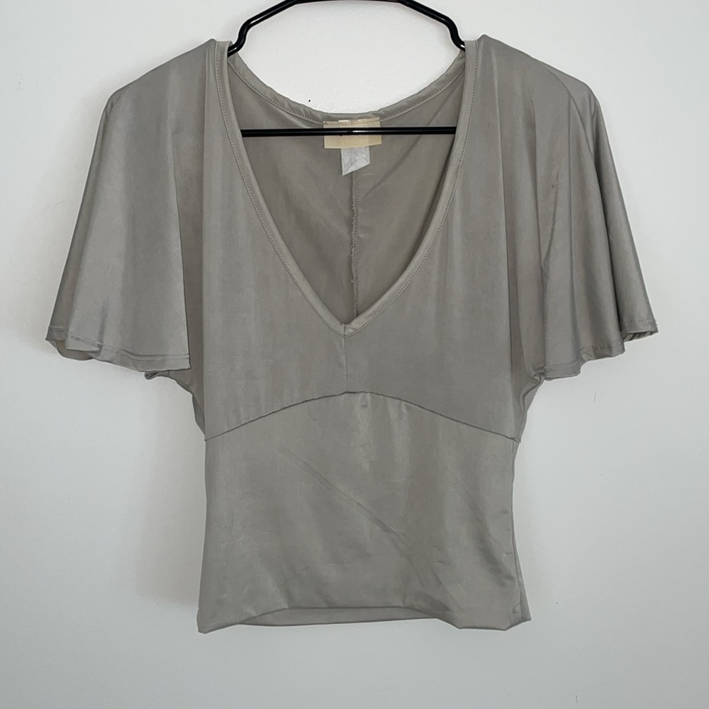 Smooth silver top with ruffle sleeves, and a plunging neckline